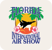 Logo for the Florida International Air Show featuring a jet silhouette, palm trees, a sunset, pink hibiscus flowers, and subtle conCHAIRto elements woven into the vibrant design.